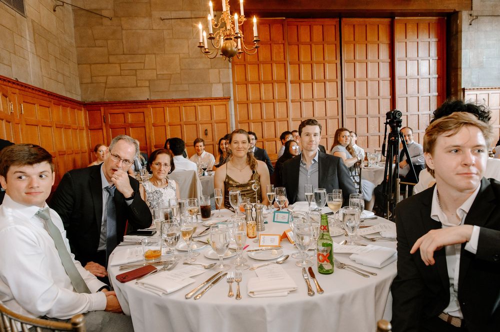 Wedding reception tables set with glowing candles in a rustic stone dining hall.