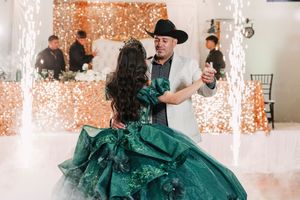 Celebration in event hall with sparkling lights and emerald green formal attire.