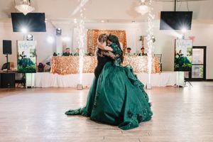 Spacious white reception venue decorated with twinkling lights and emerald green accents.
