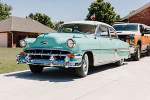 Vintage turquoise classic cars from the 1950s lined up in a row on display at an outdoor show.