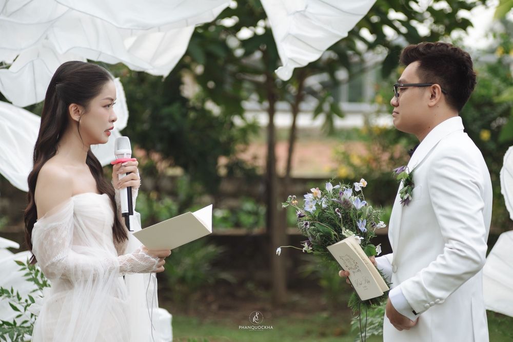 Bride and groom exchanging vows at elegant outdoor garden wedding ceremony.