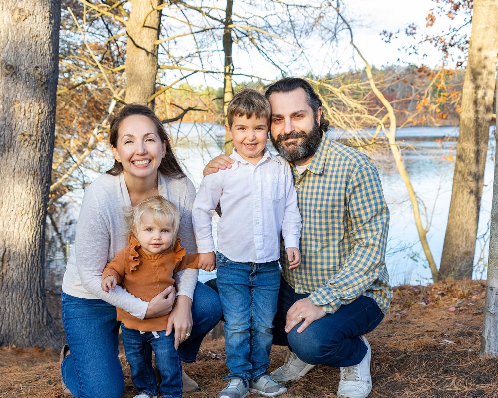 A family poses for a fall portrait with their during family photo session at Lake Cochituate in Natick, MA with Lisa West Photography.