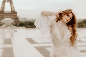 Romantic photoshoot with the Eiffel Tower as a backdrop features figure in flowing white dress at Trocadero in Paris.