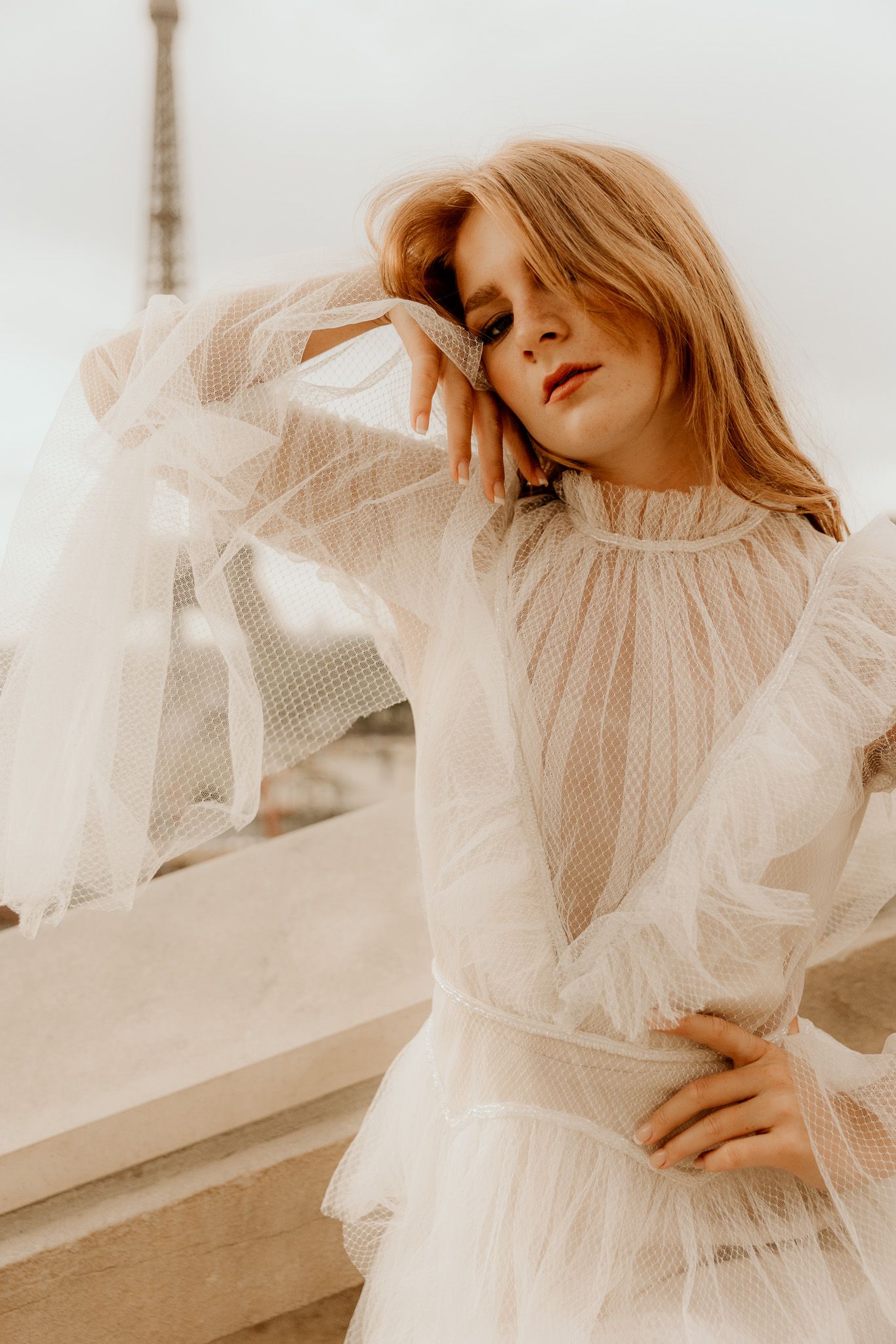 Ethereal fashion portrait series featuring soft tulle fabric and dreamy beige tones in natural light.