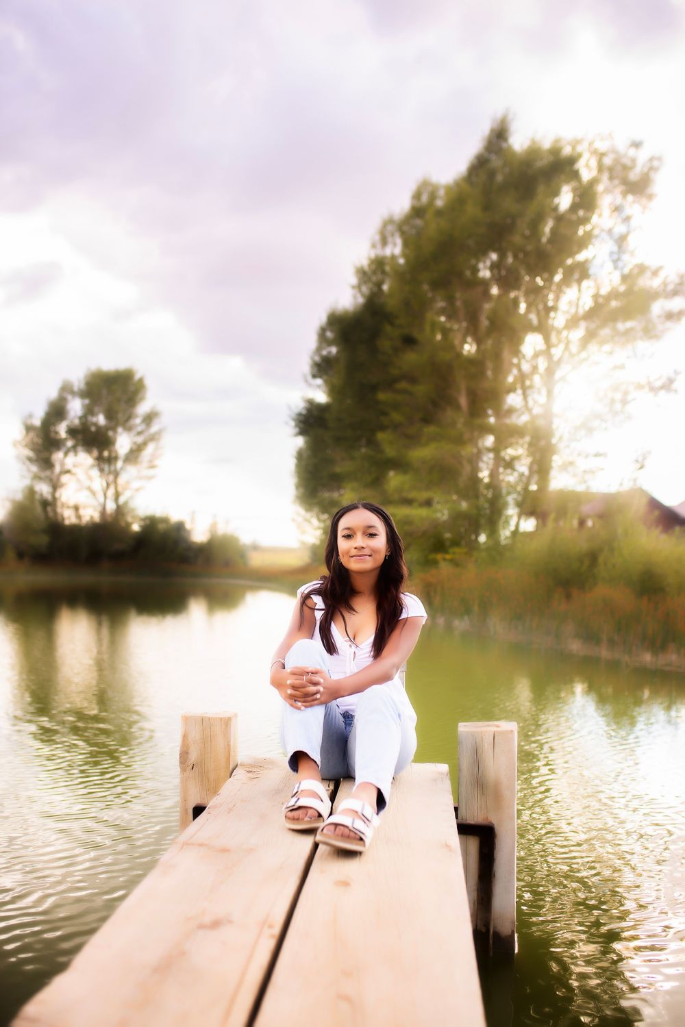 A sequence of photos shows someone sitting on a wooden dock by a tranquil lake during sunset with trees in background.