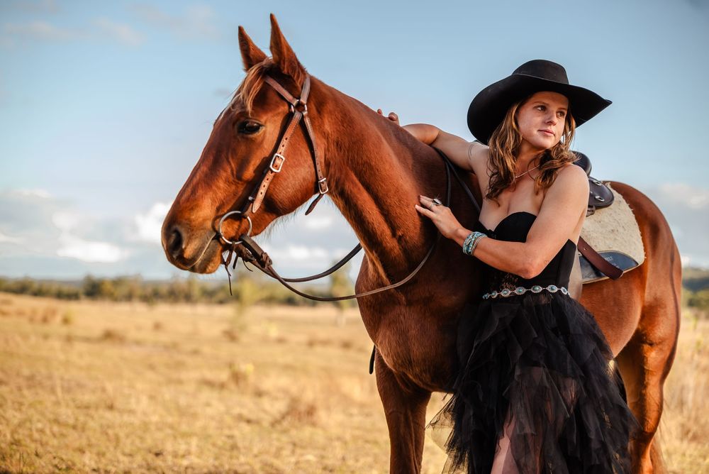 A series of five photos shows a person in black riding a chestnut horse while posing in a golden field at sunset.
