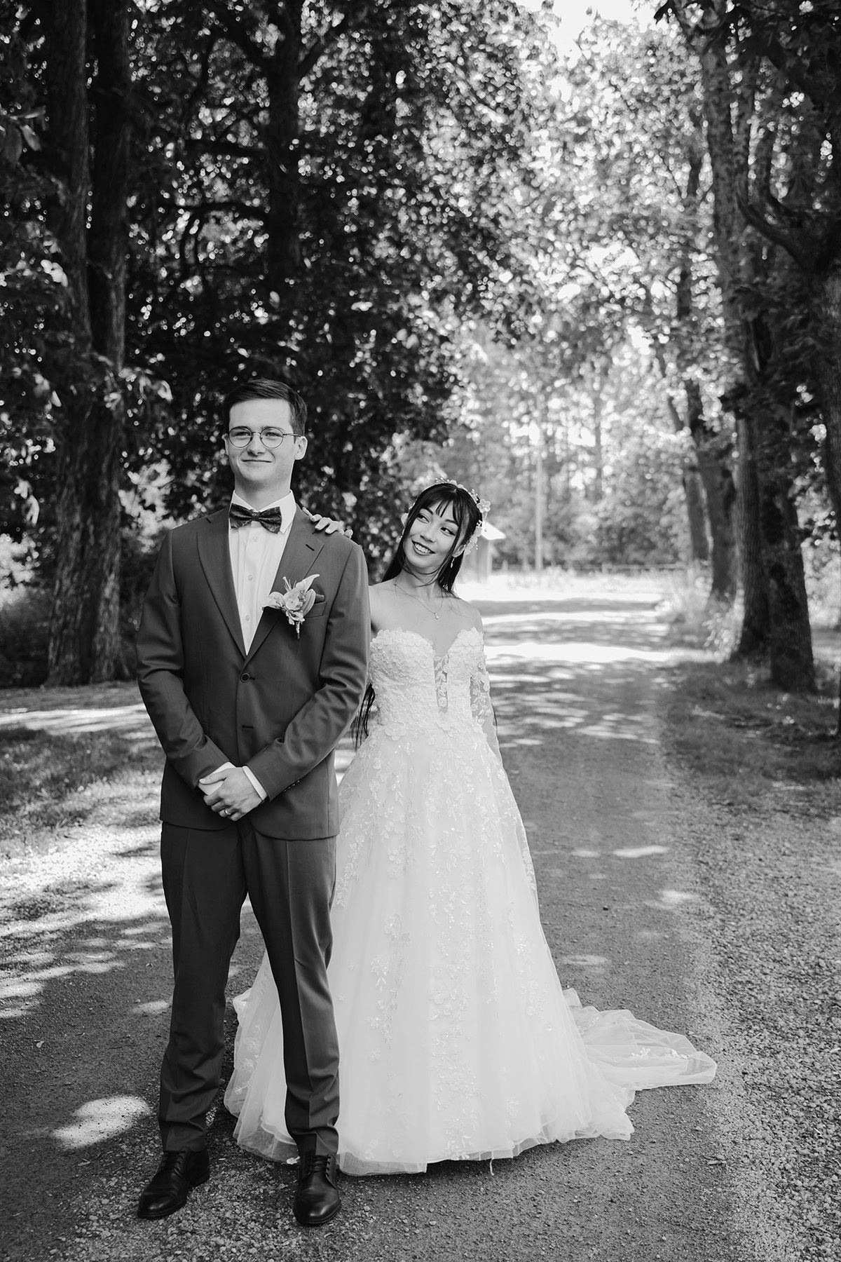 First Look vid bröllop i Östergötland – bruden lägger försiktigt sin hand på brudgummens axel innan han vänder sig om. Foto Lets Bloom Media
