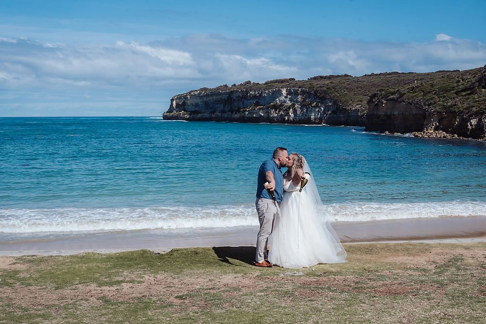 Coastal wedding photography session with cliffs and turquoise ocean waters creating a dramatic backdrop.
