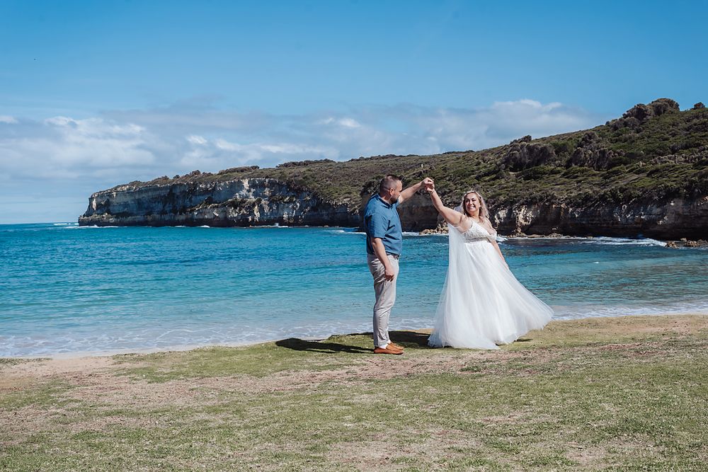Scenic coastal wedding ceremony panorama showing cliffside beach views and turquoise waters along a Hawaiian shoreline.