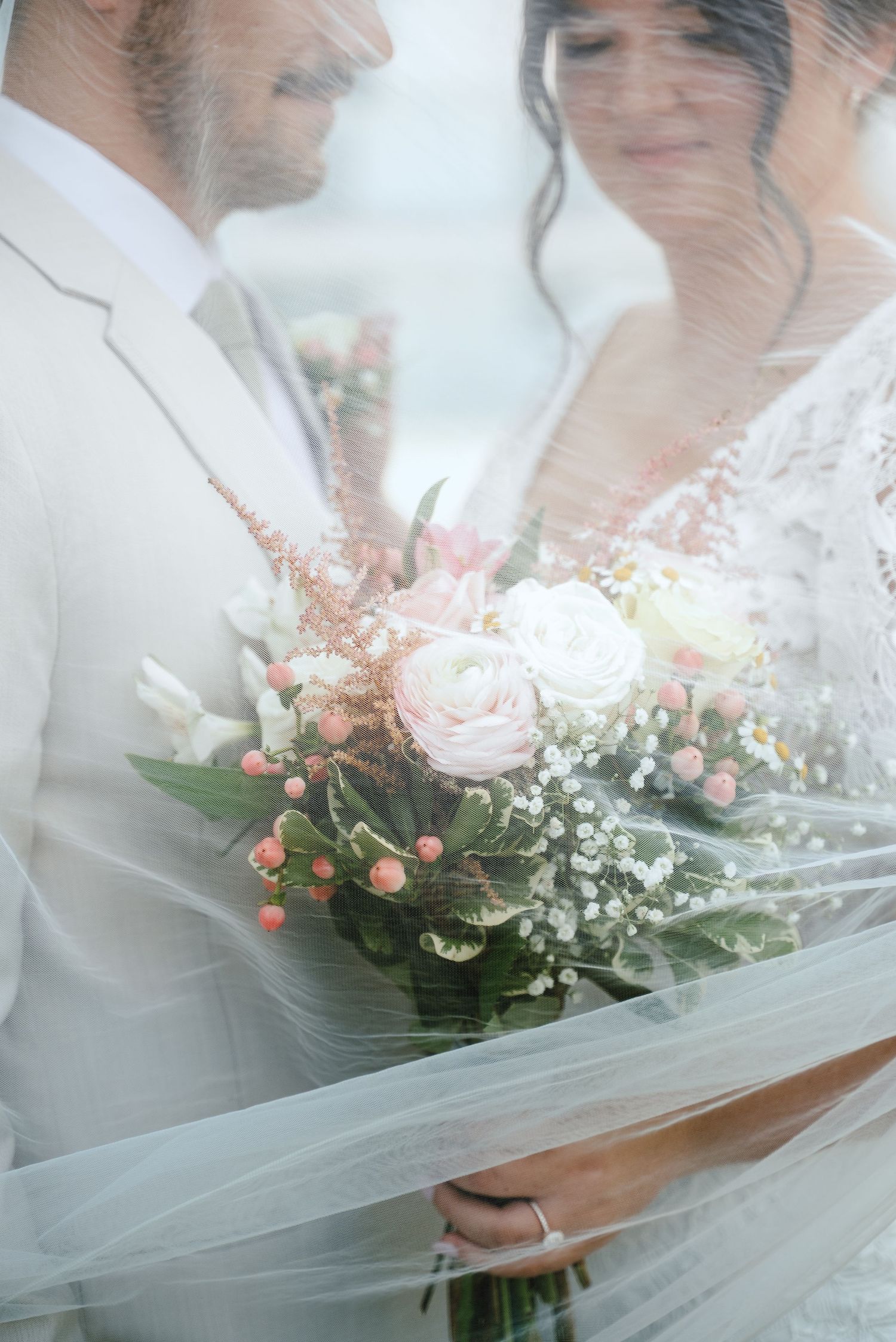 A dreamy wedding photography sequence showing the bride and groom with a soft pink and white floral bouquet through a veil.