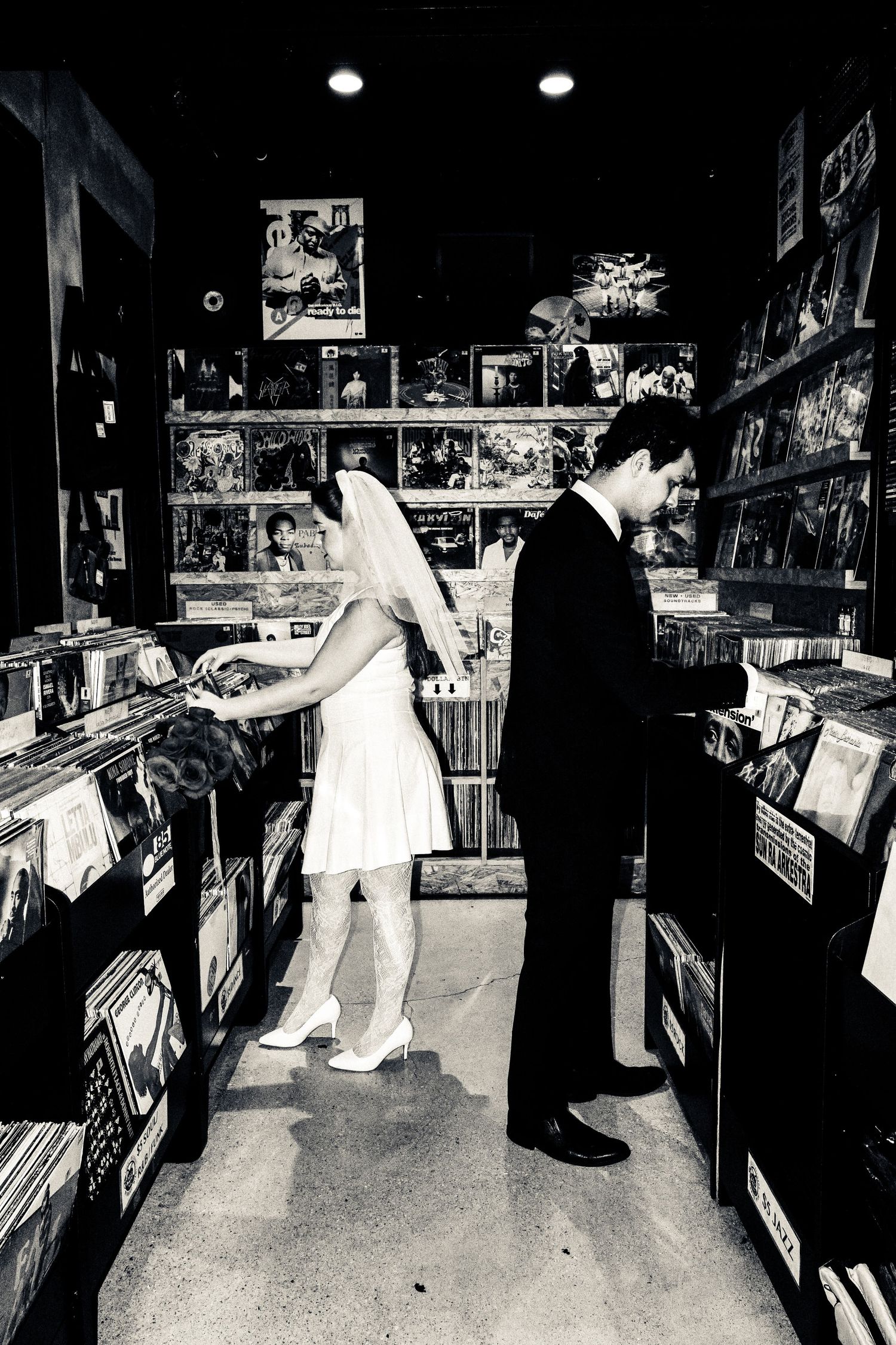 Customers browse through vinyl records and music albums in a dimly lit record store.