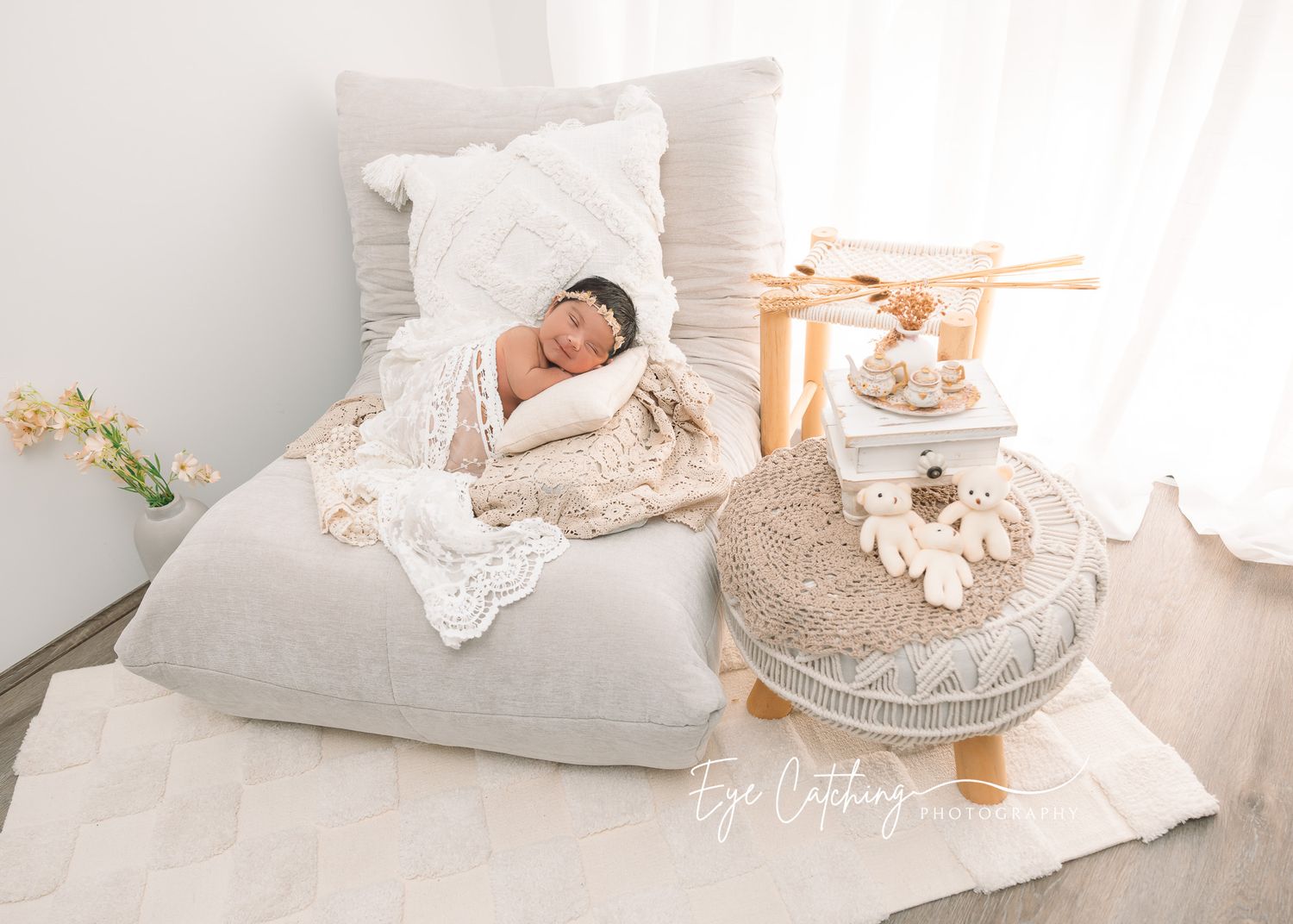 Newborn photography with purple knit accessories and delicate flowers arranged in a rustic basket.