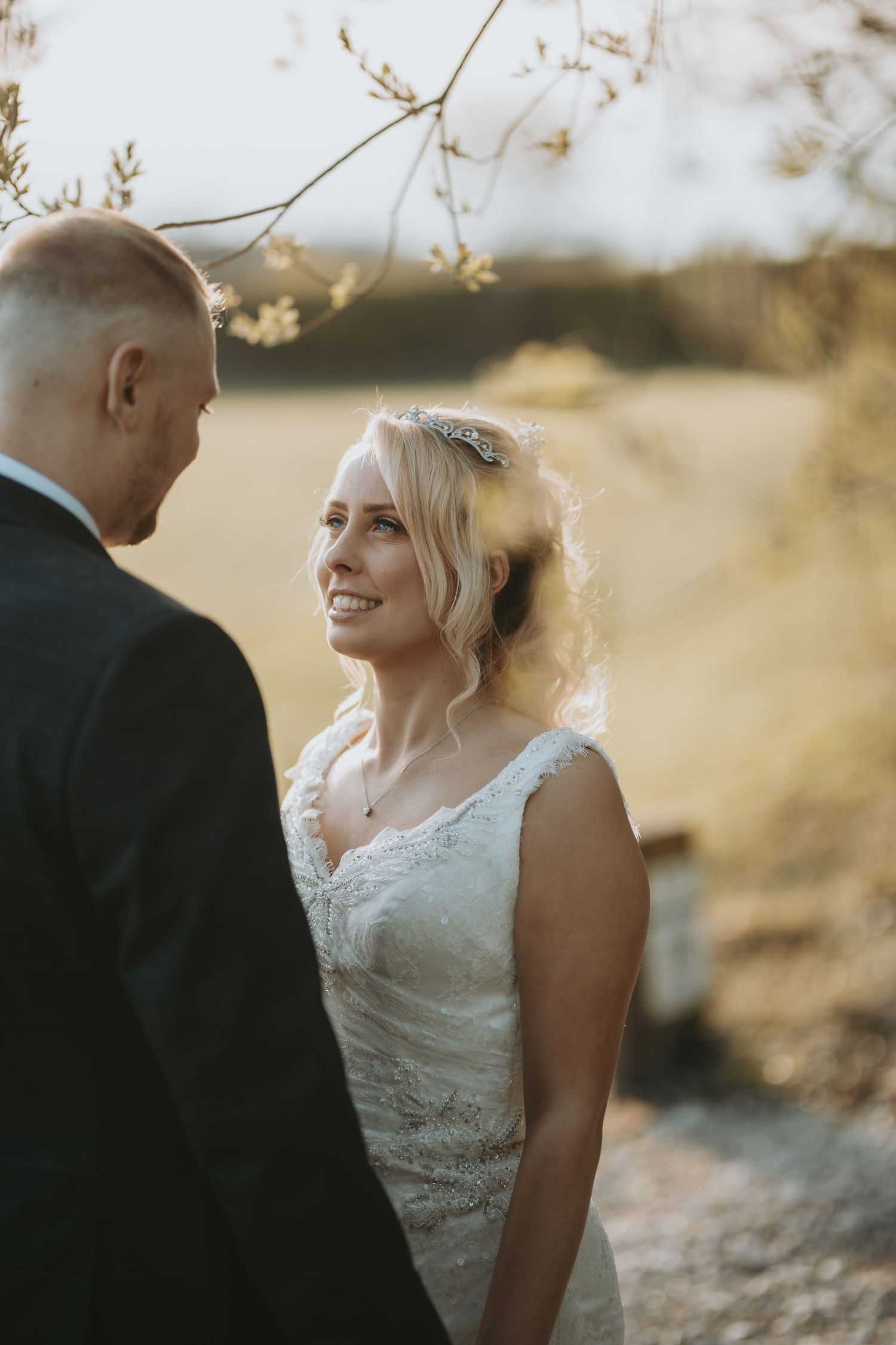 Bride and groom share intimate moments during sunset wedding photography session in natural outdoor setting.