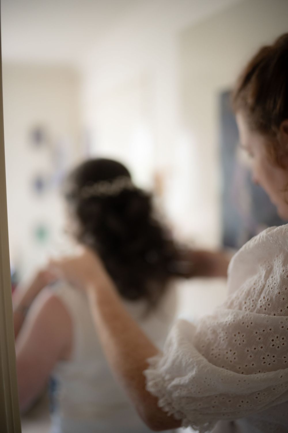 A series of soft focus, dreamy bridal preparation shots featuring white lace and delicate details.