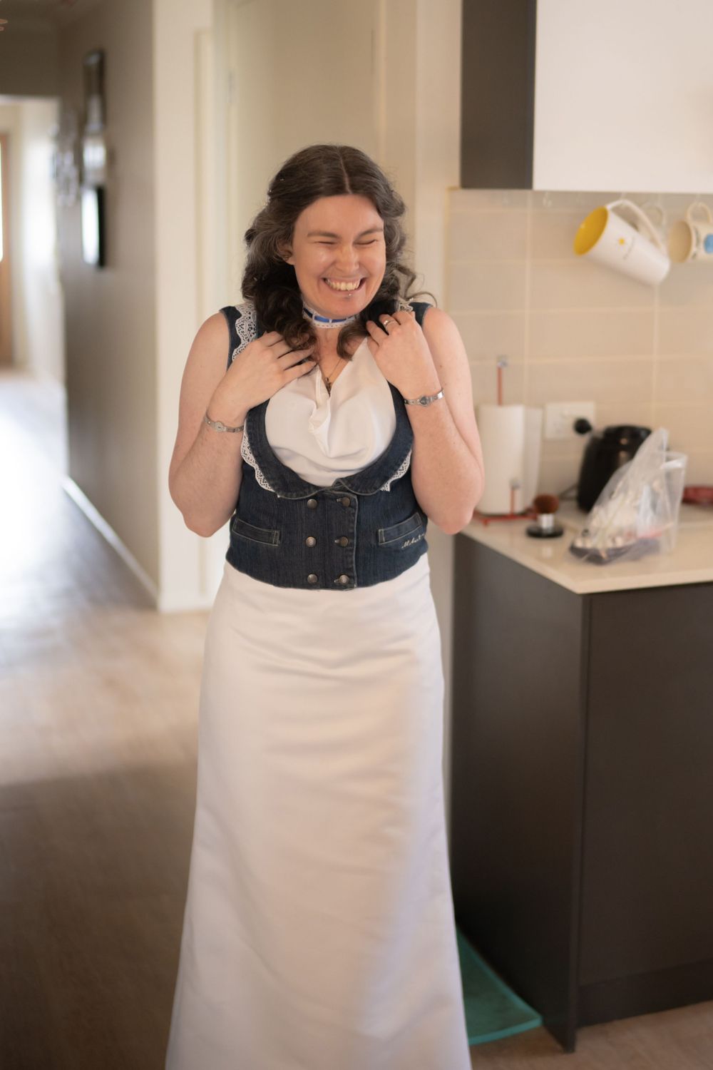A progression of images shows someone laughing and reacting with humor while wearing a white and dark colored outfit.
