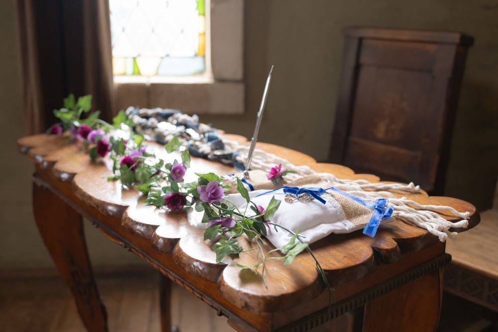 Decorative purple flowers and rustic table settings arranged on a wooden surface create an elegant dining atmosphere.