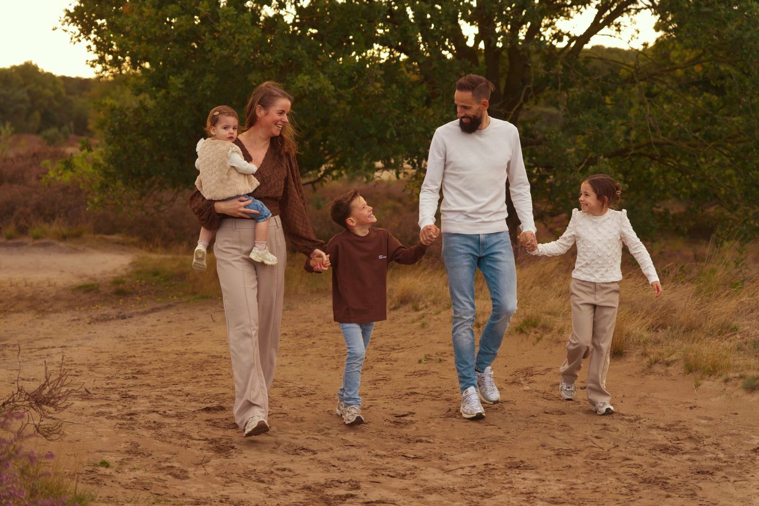 Familie tijdens buitenportret in zacht natuurlijk licht