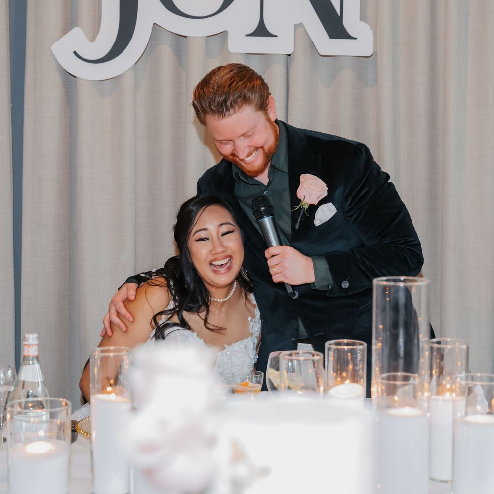 Wedding reception tables decorated with white linens and candles create an elegant atmosphere at formal celebration.