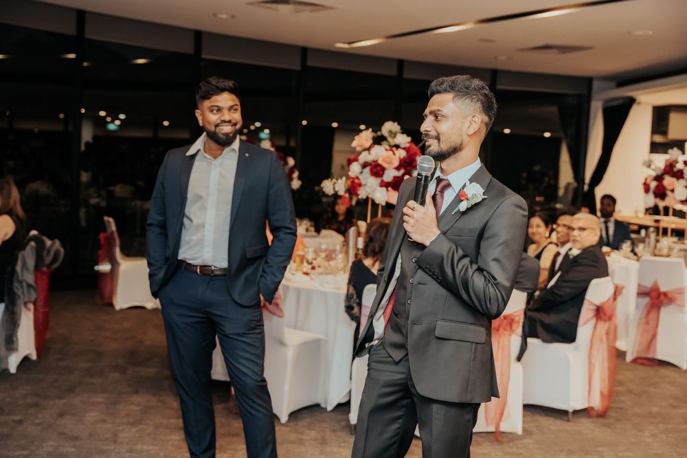 People enjoy dancing at an elegant wedding reception in a banquet hall with white table settings.