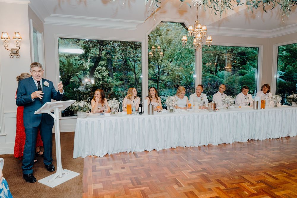 Elegant wedding reception venue with white tablecloths and chandeliers in a panoramic view.