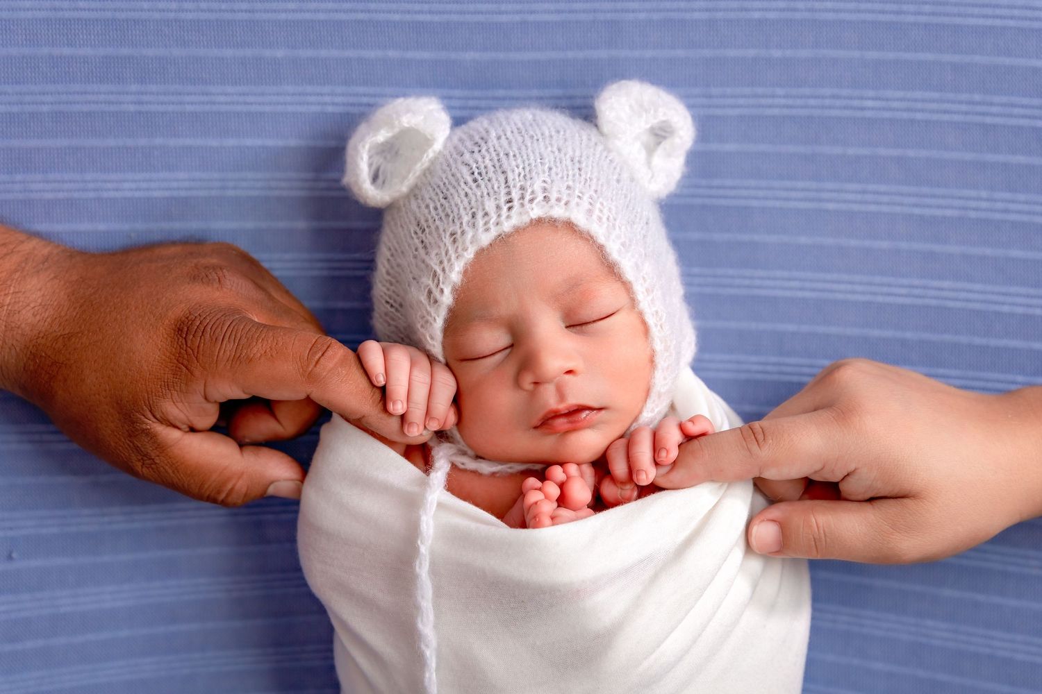 fresno newborn holding parents hands captured in northwest fresno studio