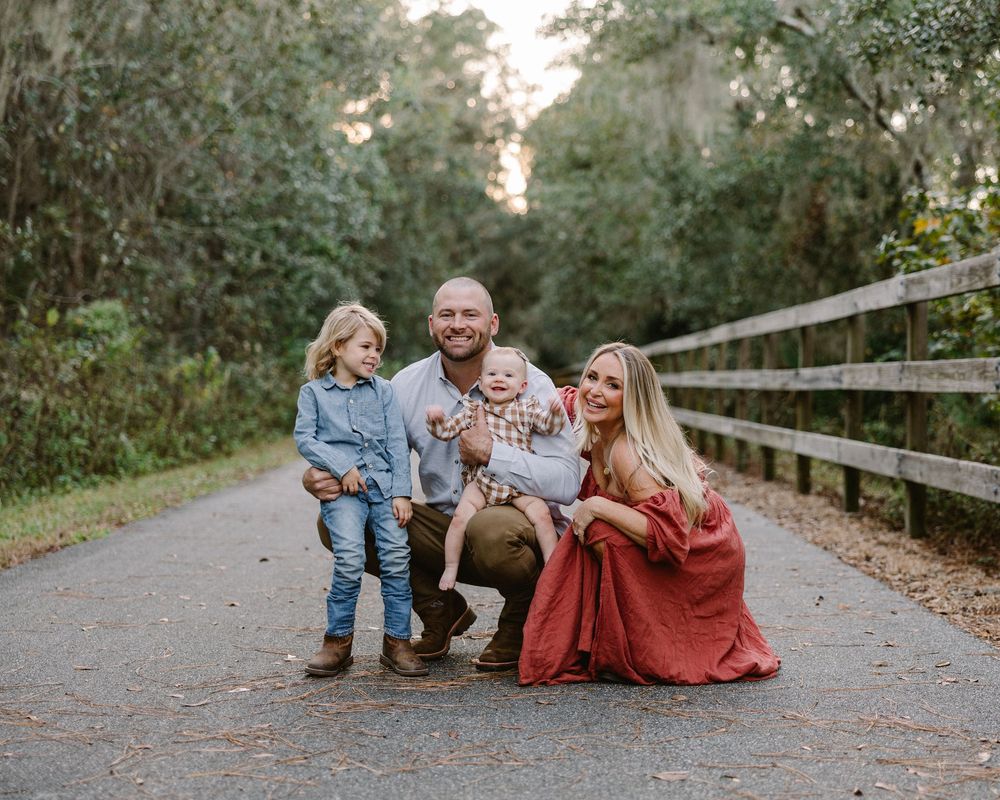 A series of candid family photos taken on a rustic wooden bridge path surrounded by lush greenery.