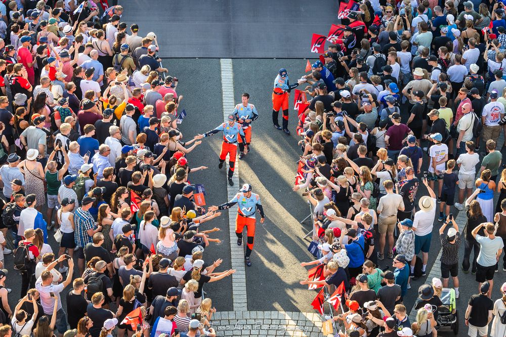 Aerial view of a large crowd of people walking on a crosswalk in an urban setting during a busy day.