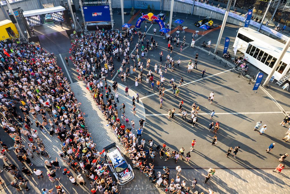 Aerial view of marathon runners and spectators gathering outside a stadium during a sporting event.