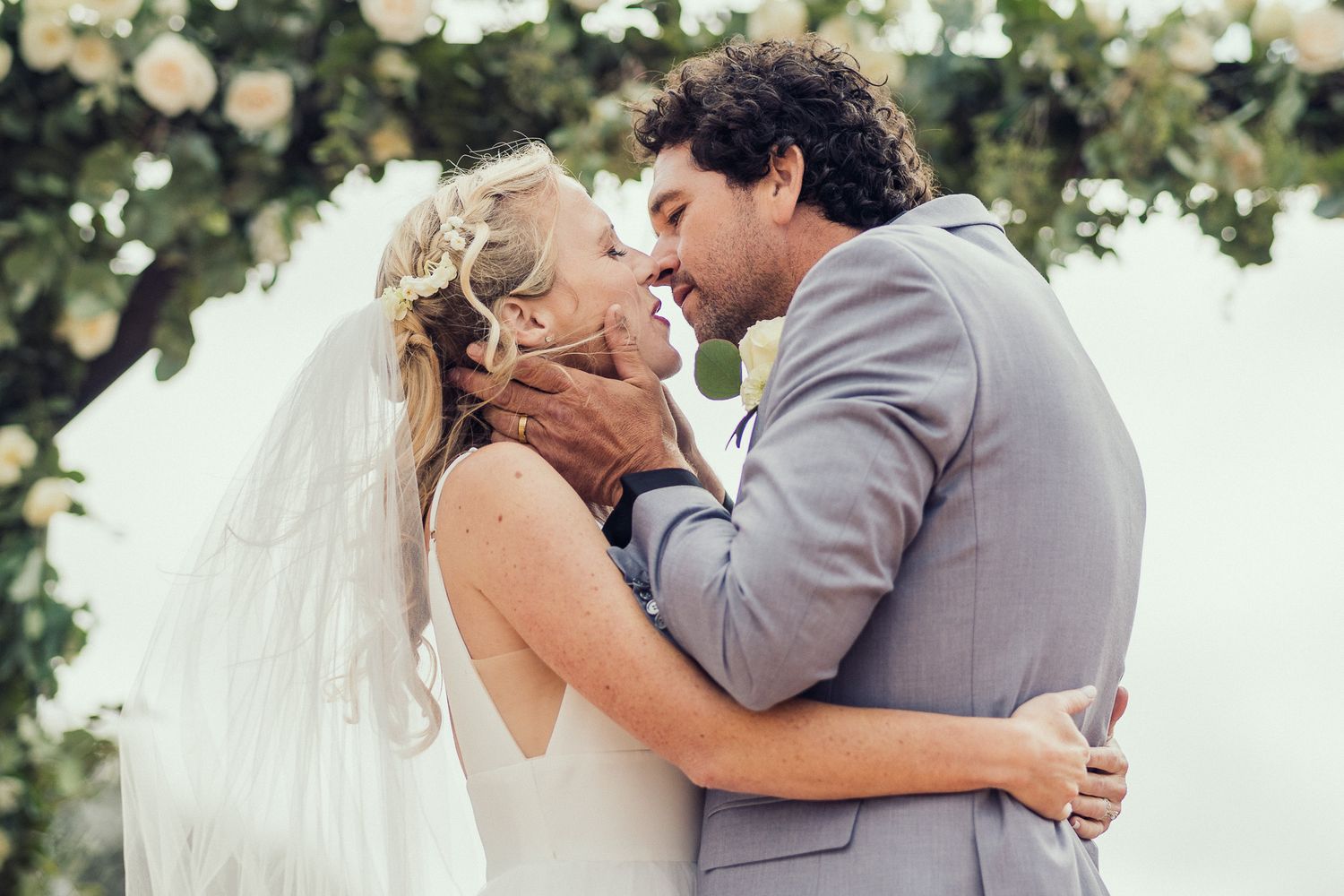 A romantic wedding couple shares intimate kisses in a series of black and white outdoor photos.