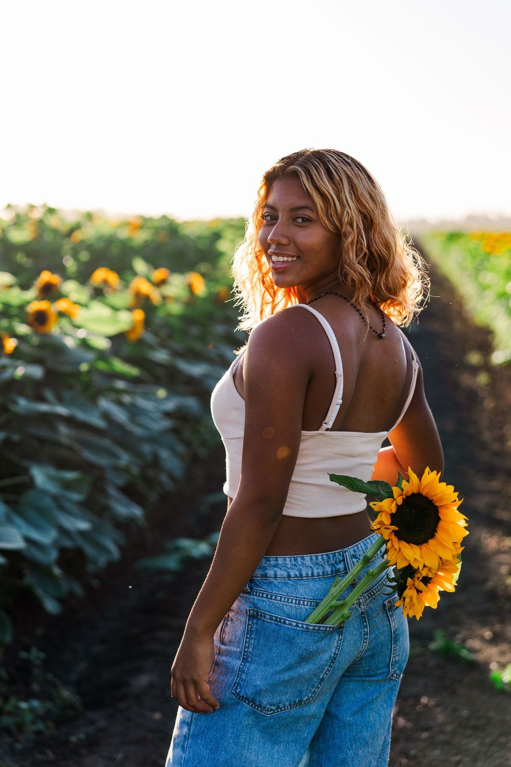 Senior portrait in a golden sunflower field at Conejo Family Farms, Camarillo — timeless, natural, and full of vibrant summer charm.