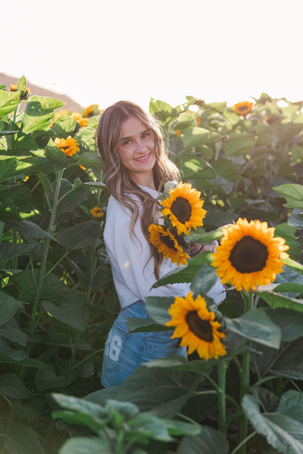 Senior portrait in a golden sunflower field at Conejo Family Farms, Camarillo — timeless, natural, and full of vibrant summer charm.