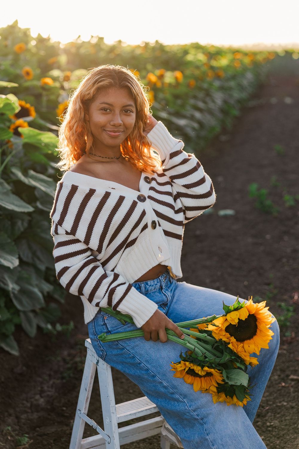 Senior portrait in a golden sunflower field at Conejo Family Farms, Camarillo — timeless, natural, and full of vibrant summer charm.