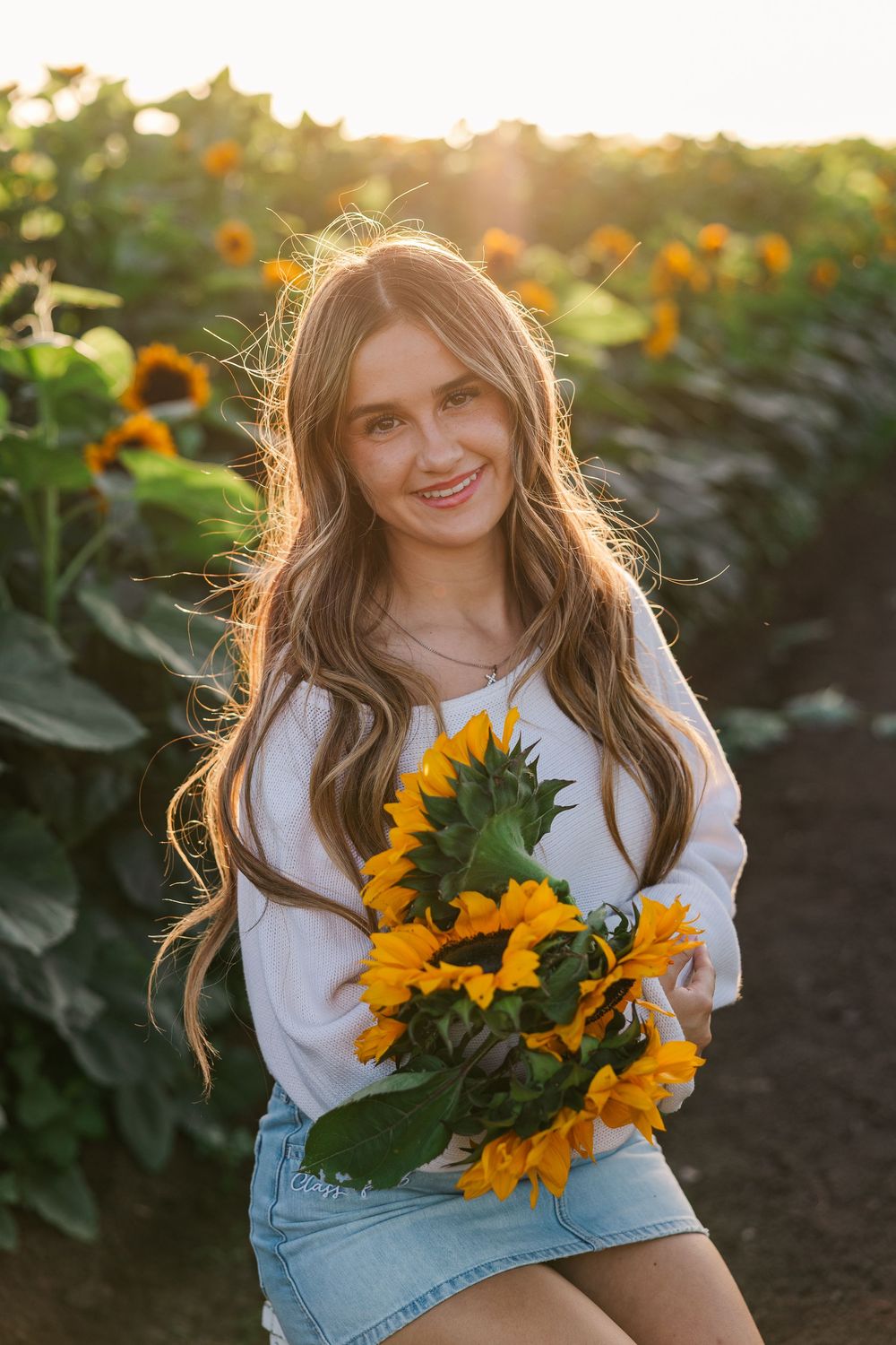 Senior portrait in a golden sunflower field at Conejo Family Farms, Camarillo — timeless, natural, and full of vibrant summer charm.