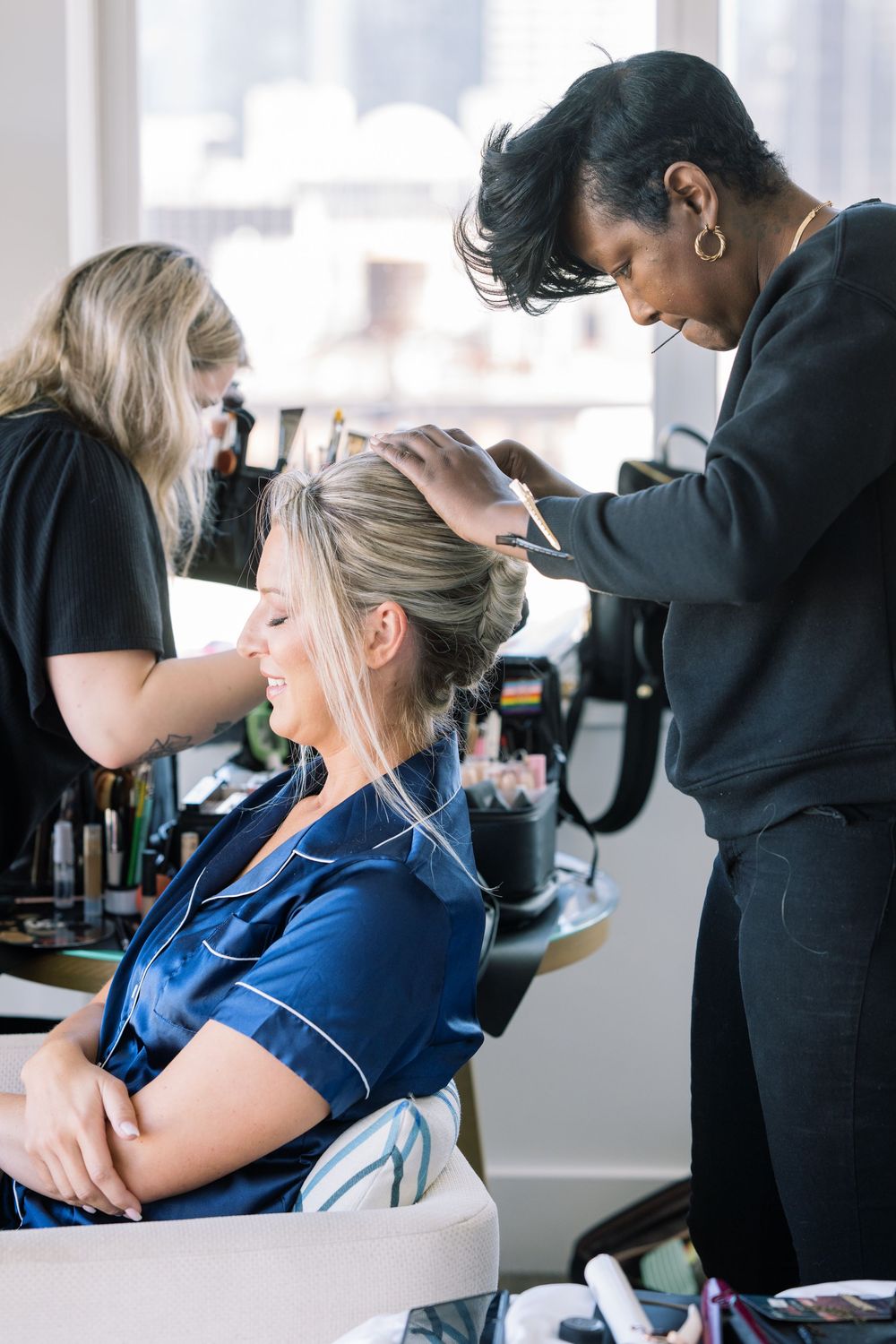 Makeup artist working with client in bright studio setting.