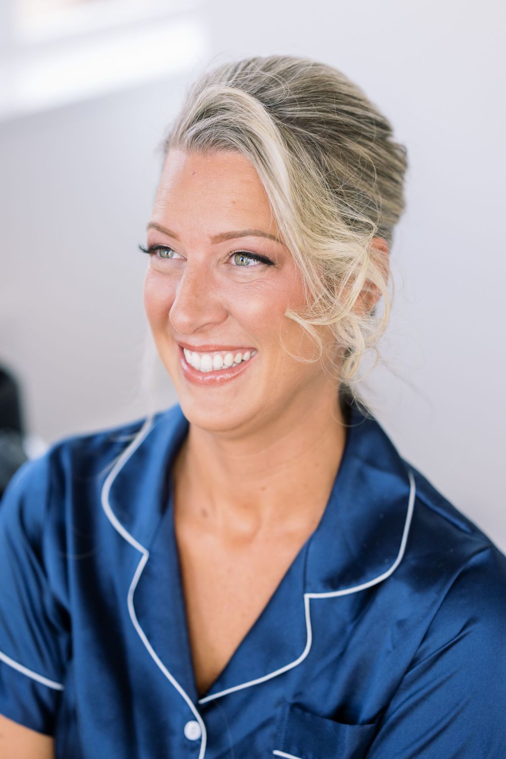 Professional wearing navy blue uniform with white piping smiling.