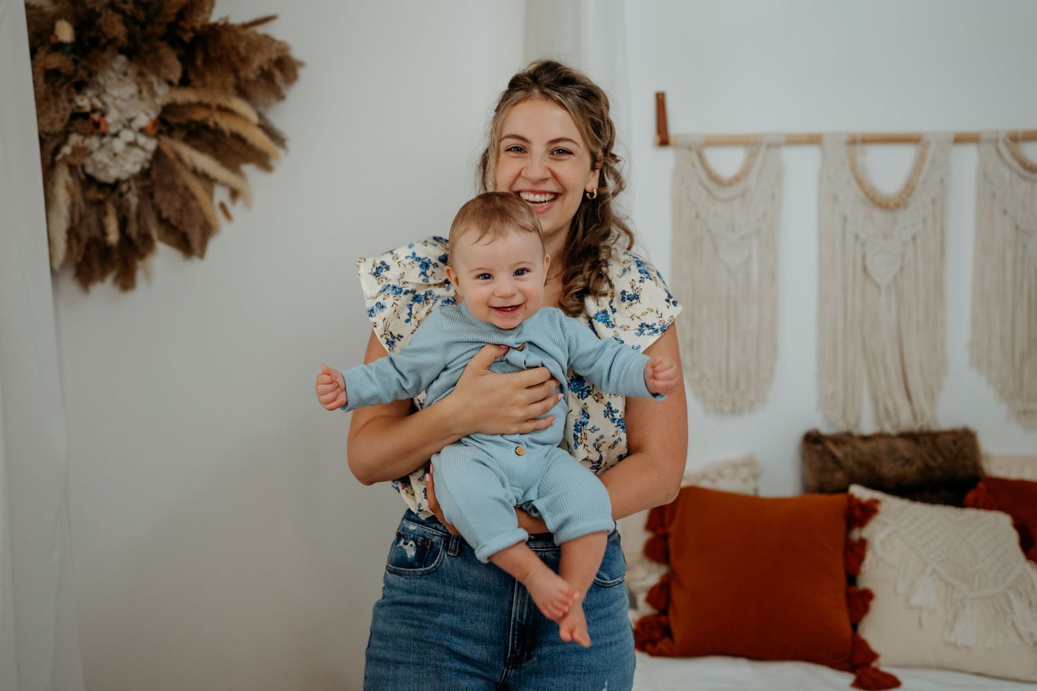 Family members wearing coordinated blue floral outfits pose together in a bright living room setting.