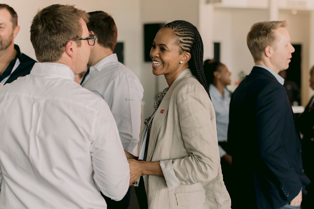 Business professionals networking and smiling during a corporate conference event.