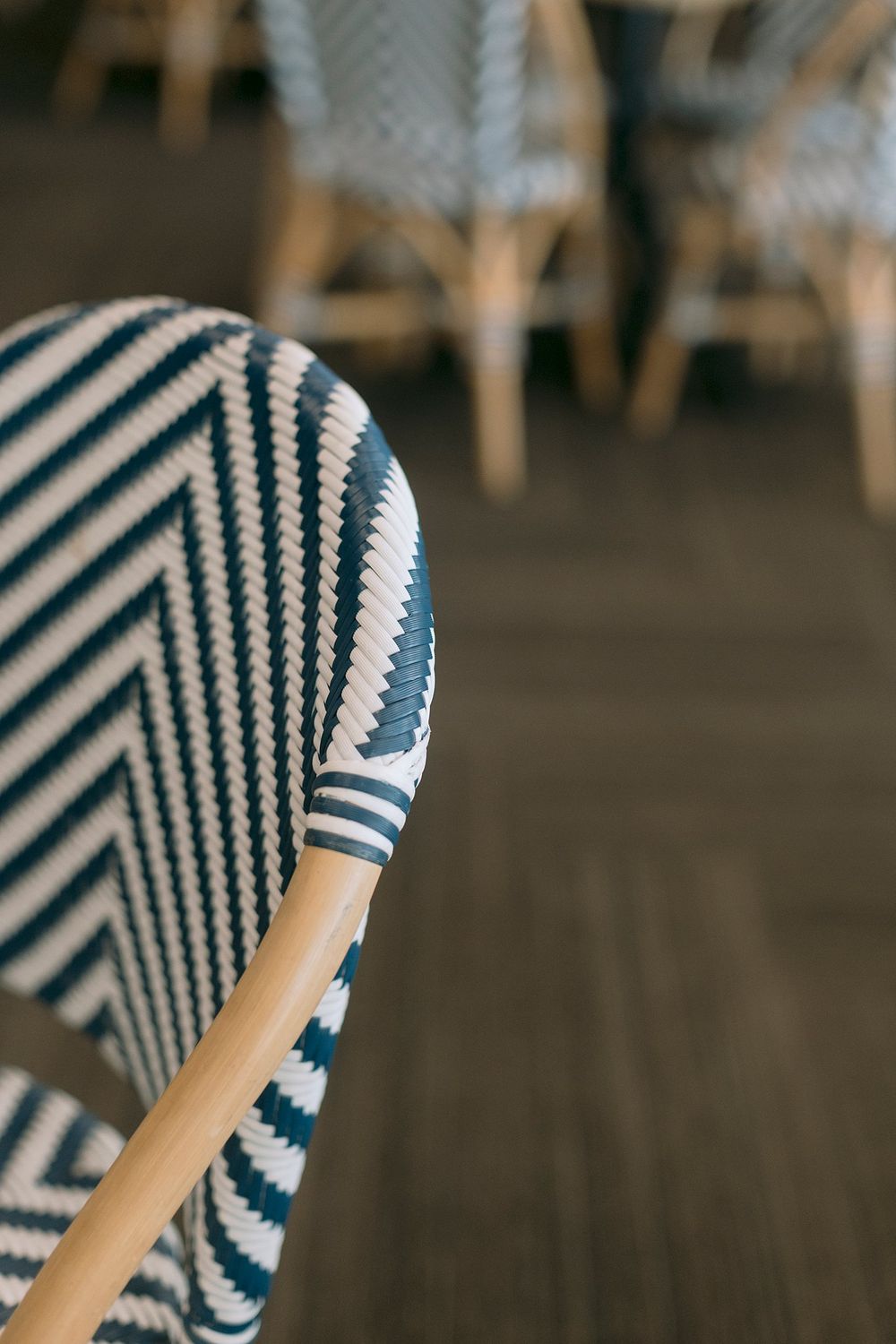 Close-up detail of a blue and white chevron patterned woven rattan bistro chair back.