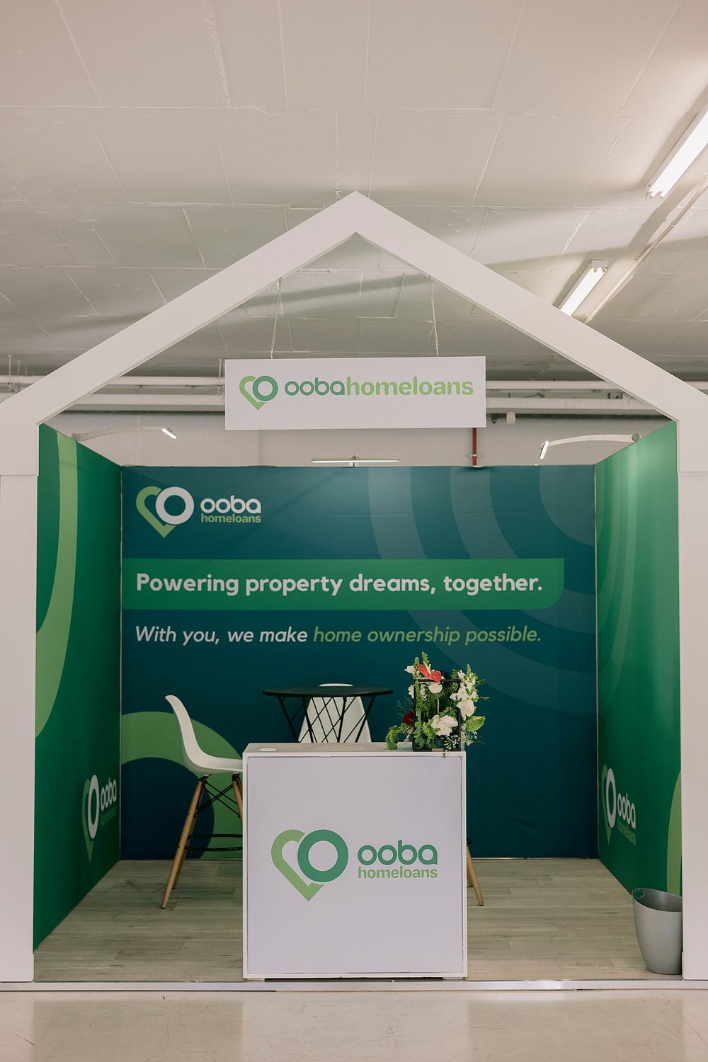 Ooba Home Loans branded exhibition booth with green decor and slogan powering property dreams together.