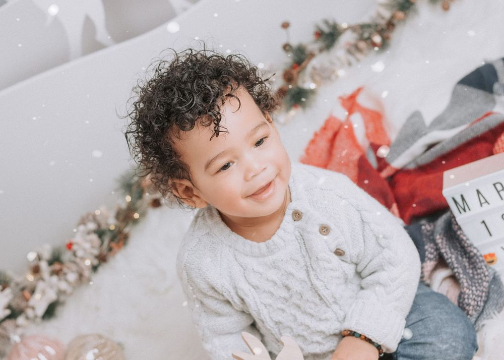 A series of holiday-themed photos featuring a child with curly hair in various festive poses against a light background.