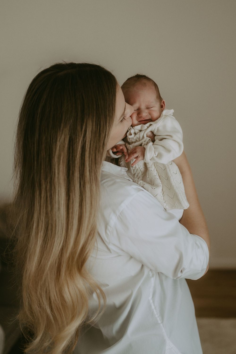 Baby wird von Mama geküsst