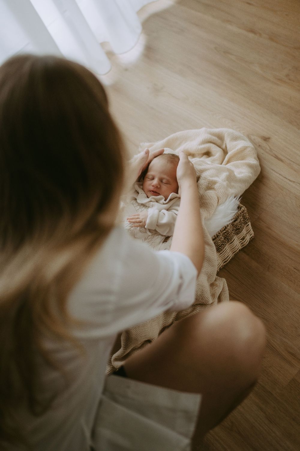 Baby wird von Mama in einen Korb gelegt