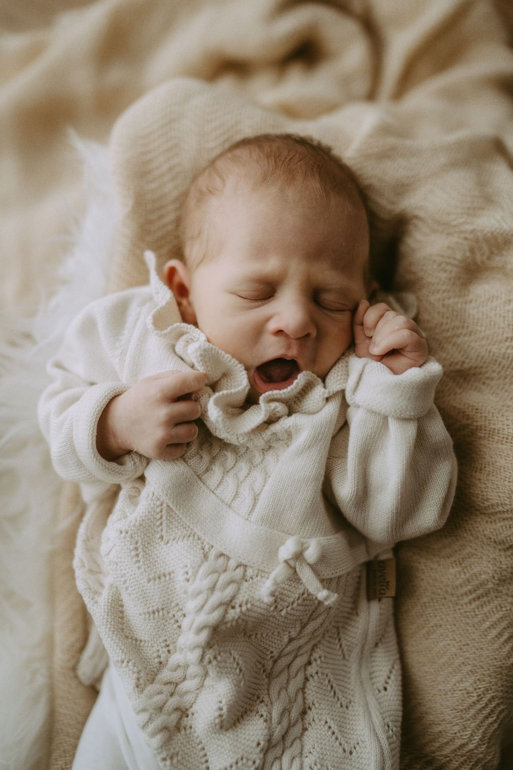 Baby gähnt und liegt auf einer Decke