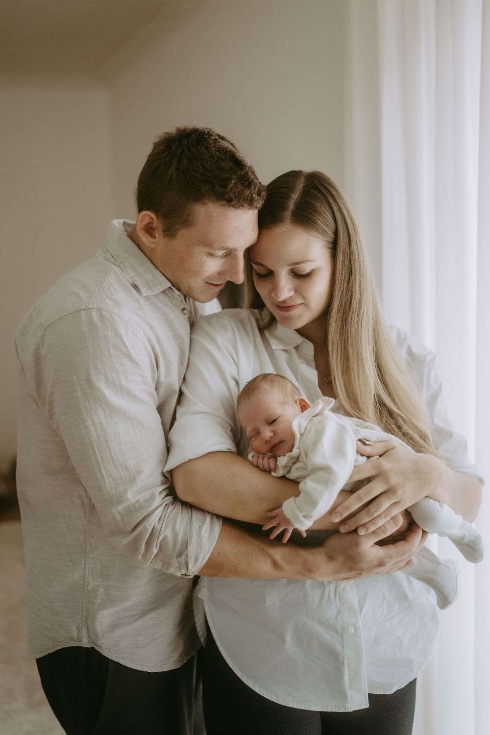 Mama und Papa halten das Baby im Arm