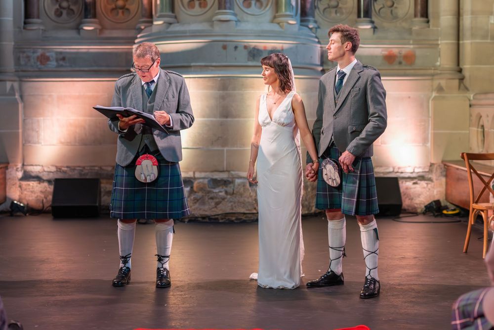 Wedding ceremony moments captured on a red carpet in a beautifully lit historic venue.