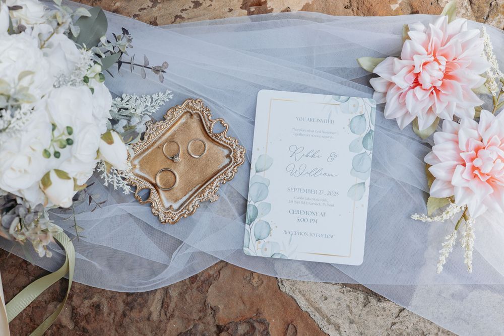 Elegant wedding invitation suite styled with pink dahlias and flowing fabric.