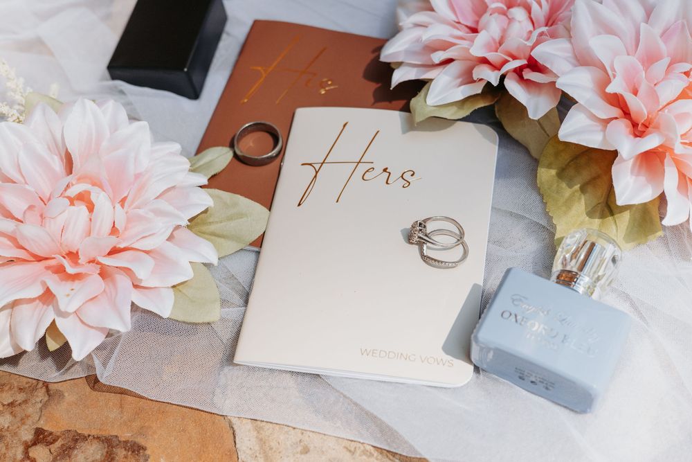 Wedding stationery flatlay with pink flowers and delicate paper details.