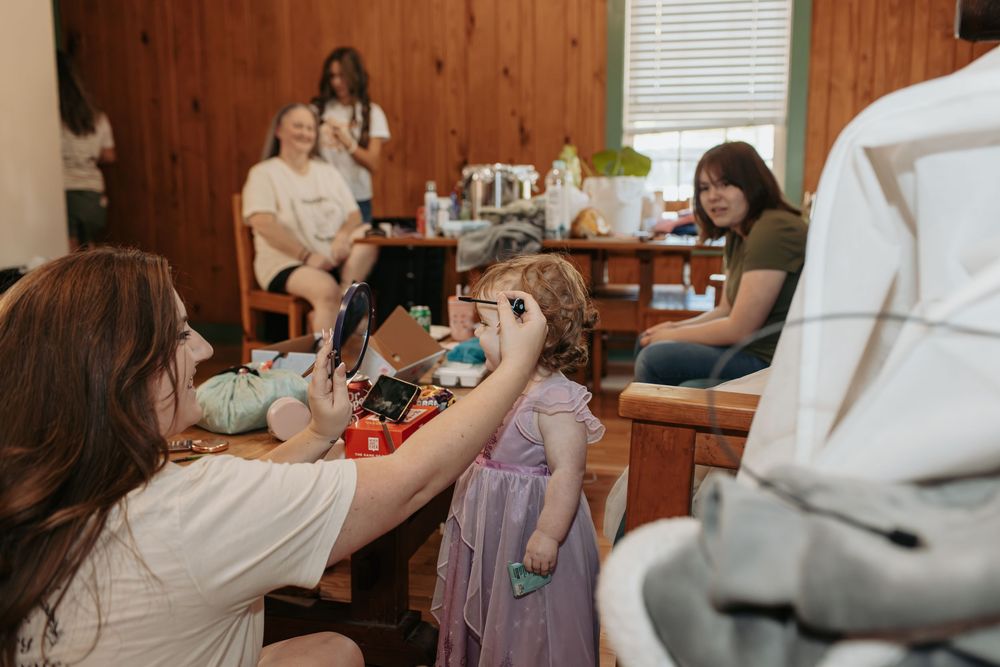 Wedding preparation scene in wood-paneled room with people getting ready.