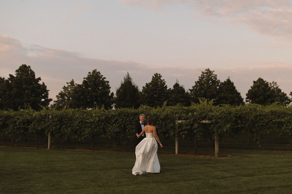 Wide landscape shot of a wedding venue with chairs set up outdoors at dusk.