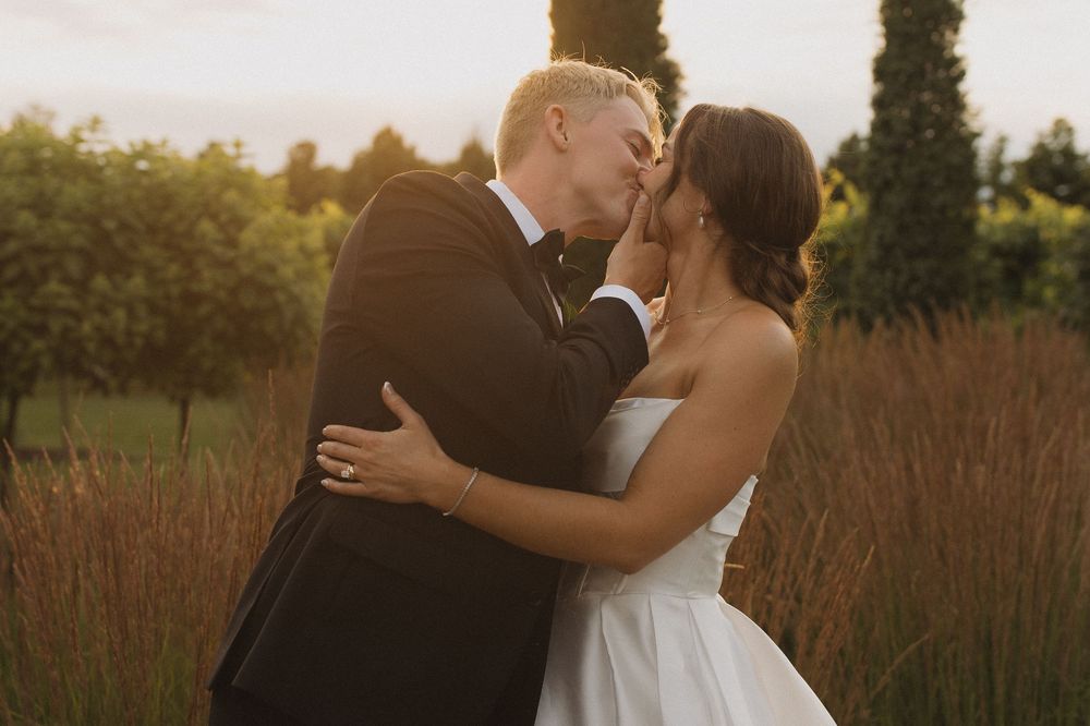 Romantic wedding couple embracing during golden hour photography session.